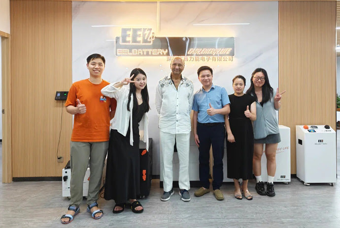 EEL battery employees take photos with visiting customers at the front desk